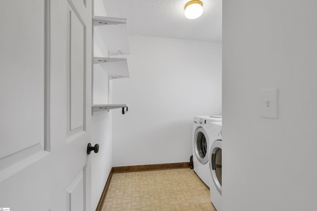 laundry area with baseboards, separate washer and dryer, laundry area, and a textured ceiling