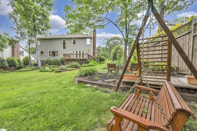 back of house with a yard, a deck, and fence