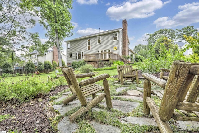 back of house with fence, a wooden deck, and a chimney