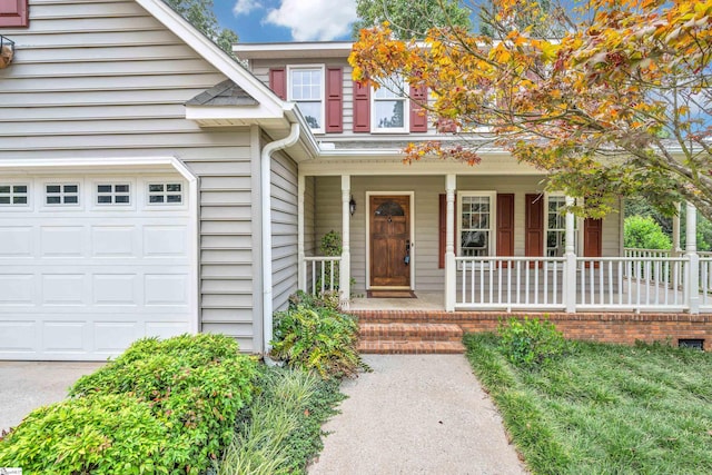 view of exterior entry with a porch and an attached garage