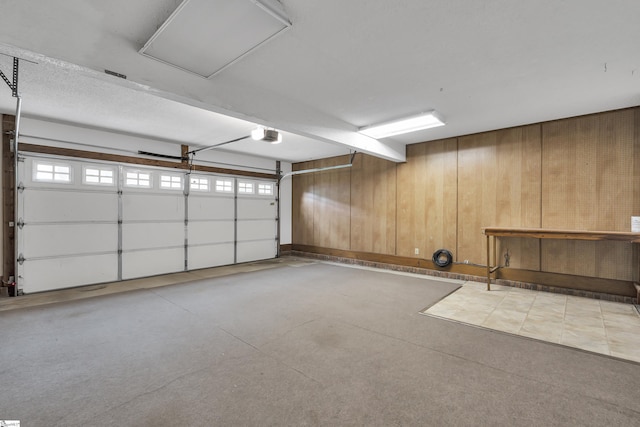 garage featuring wooden walls and a garage door opener
