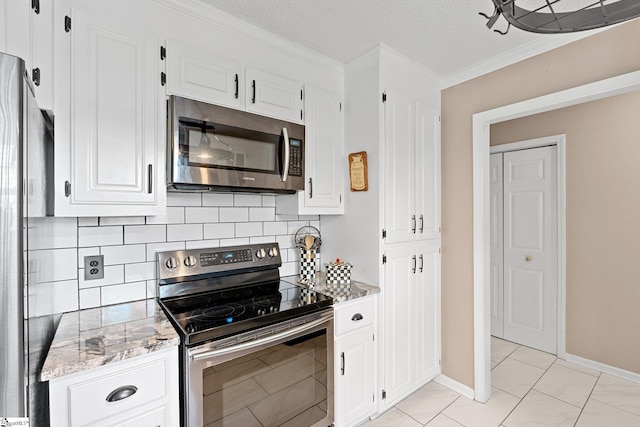 kitchen featuring ornamental molding, white cabinetry, backsplash, light stone countertops, and appliances with stainless steel finishes
