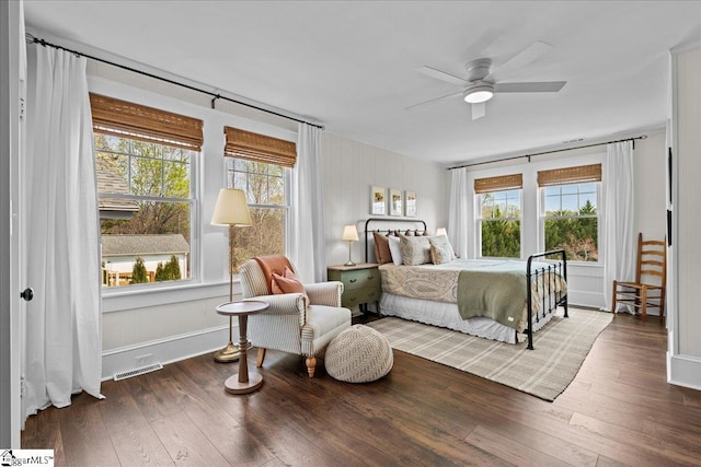 bedroom featuring visible vents, baseboards, a ceiling fan, and wood finished floors