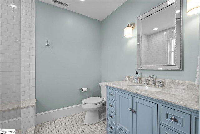 full bath with vanity, baseboards, toilet, tiled shower, and visible vents