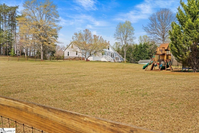 view of yard featuring fence and a playground