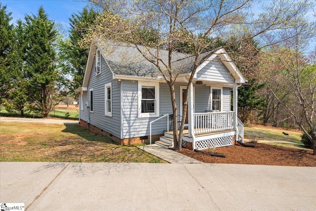 bungalow-style house with crawl space, a front lawn, a shingled roof, and covered porch