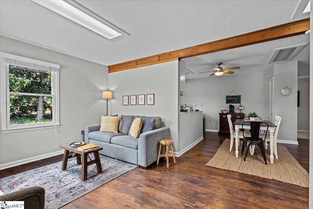 living room with visible vents, baseboards, ceiling fan, beam ceiling, and wood finished floors