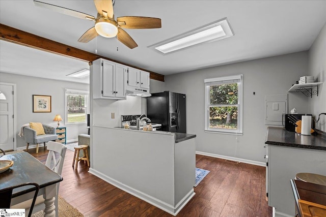 kitchen featuring white cabinets, a wealth of natural light, ceiling fan, and black fridge