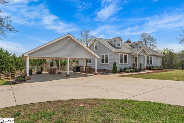view of front of house with crawl space, a detached carport, fence, a patio, and driveway
