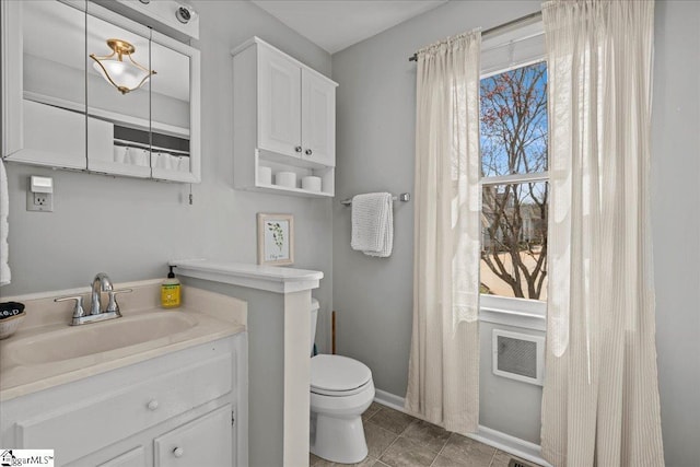 bathroom featuring toilet, vanity, baseboards, and tile patterned flooring