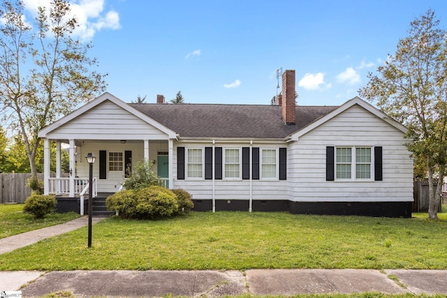 view of front of home featuring a front yard, covered porch, crawl space, a chimney, and fence