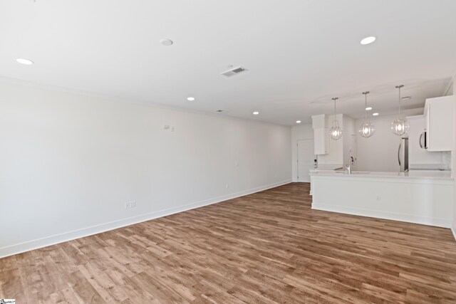 98 E Mcbee Ave Unit 205, Greenville, SC 29601 - unfurnished living room with wood finished floors, a sink, baseboards, and recessed lighting