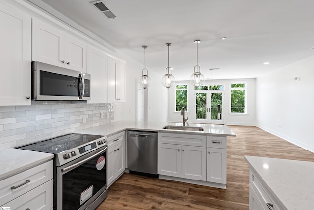 98 E Mcbee Ave Unit 205, Greenville, SC 29601 - kitchen with a peninsula, visible vents, a sink, stainless steel appliances, and decorative backsplash