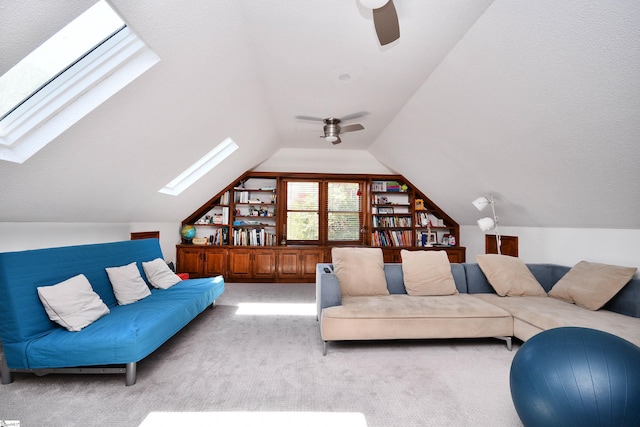 living room featuring a ceiling fan, light colored carpet, and lofted ceiling with skylight