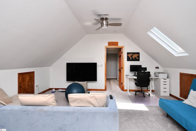 office with ceiling fan, carpet, a textured ceiling, baseboards, and lofted ceiling with skylight