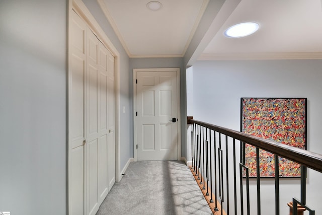 hallway with light carpet, baseboards, and ornamental molding