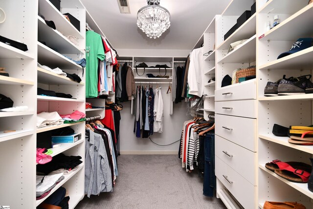 walk in closet with a chandelier, carpet flooring, and visible vents