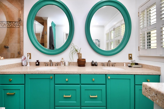 bathroom featuring crown molding, tiled shower, double vanity, and a sink