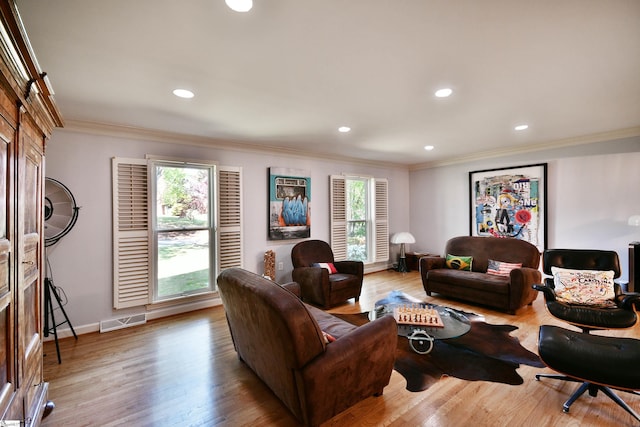 living area with crown molding, visible vents, recessed lighting, and wood finished floors
