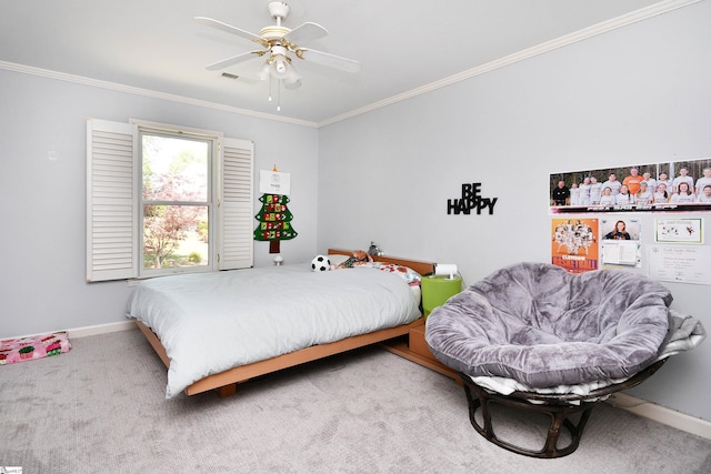 carpeted bedroom with visible vents, baseboards, ornamental molding, and a ceiling fan