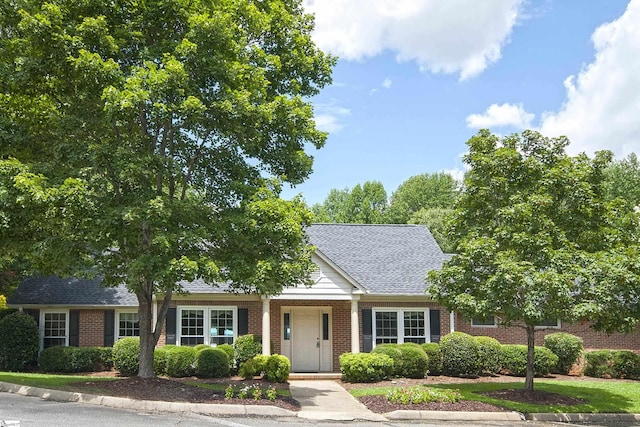 view of front of house featuring brick siding and a shingled roof