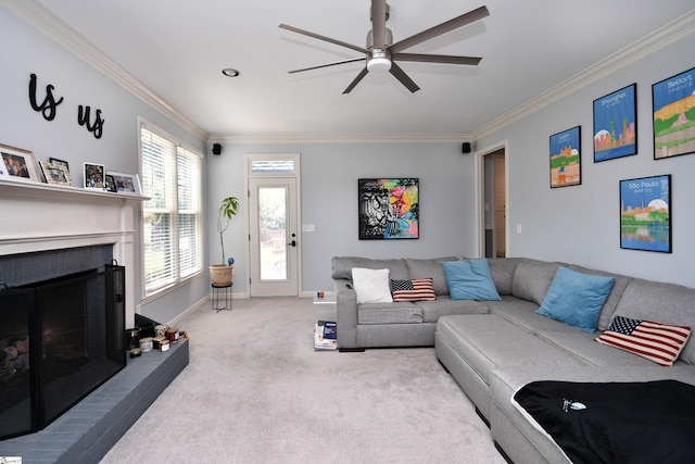 carpeted living area with a fireplace, baseboards, ornamental molding, and ceiling fan