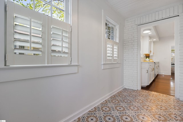 hallway featuring a healthy amount of sunlight and baseboards
