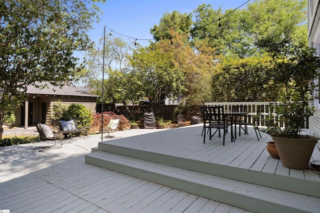 deck featuring outdoor dining space and fence