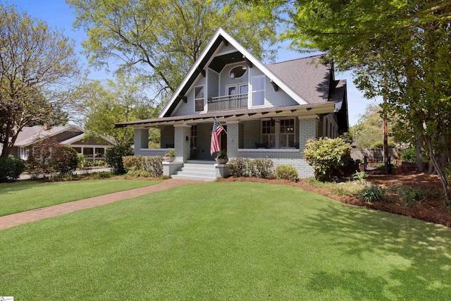 view of front of property featuring brick siding, a porch, and a front lawn