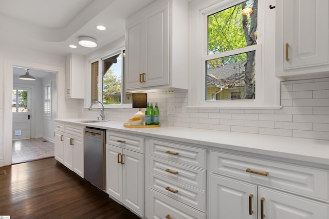 kitchen with a sink, light countertops, white cabinets, and dishwasher