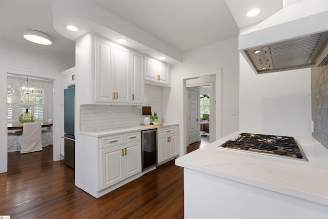 kitchen featuring a healthy amount of sunlight, range hood, beverage cooler, and appliances with stainless steel finishes
