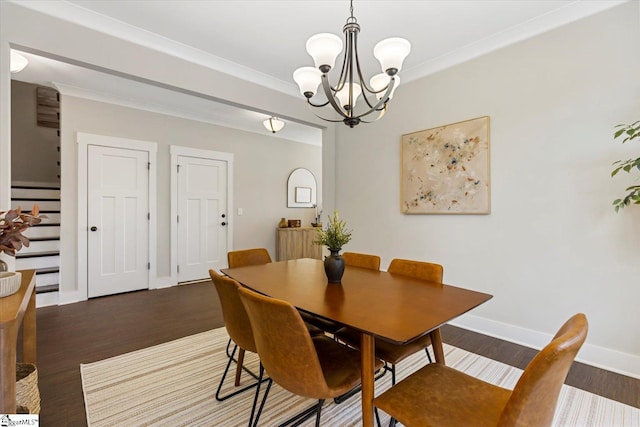 dining space with wood finished floors, a notable chandelier, ornamental molding, and baseboards