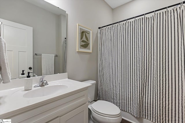 bathroom featuring toilet, a shower with shower curtain, and vanity