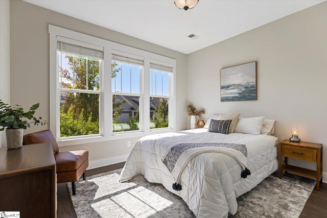 bedroom featuring visible vents, baseboards, and wood finished floors