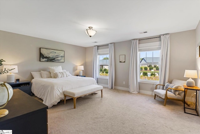 bedroom featuring visible vents, light colored carpet, and baseboards