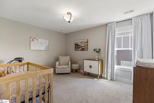 bedroom with a nursery area, visible vents, baseboards, and light colored carpet