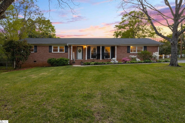 ranch-style home with brick siding and a lawn