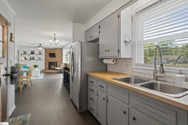 kitchen featuring tasteful backsplash, a fireplace, a sink, and a wealth of natural light