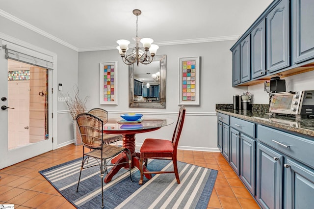 dining space featuring crown molding, light tile patterned floors, a toaster, and an inviting chandelier