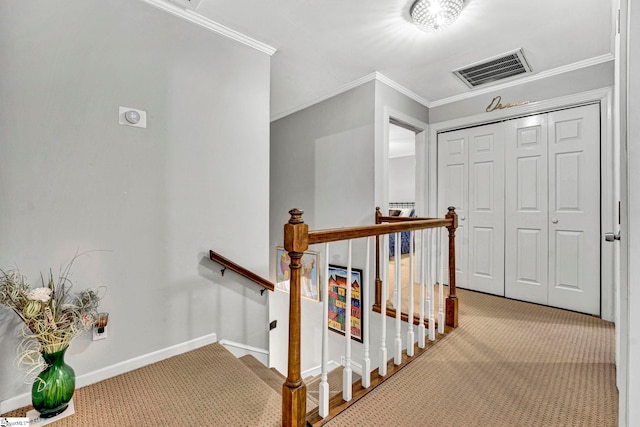 hall with an upstairs landing, visible vents, ornamental molding, and carpet