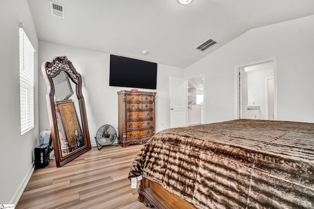 bedroom with light wood-style flooring, visible vents, and lofted ceiling