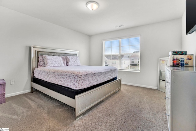 bedroom featuring visible vents, baseboards, and light colored carpet