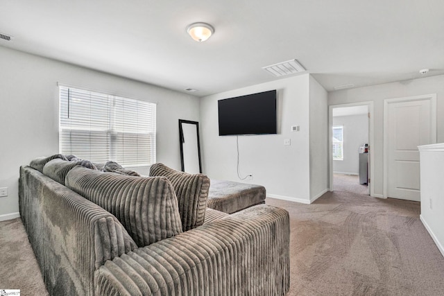 living area with light carpet, baseboards, and visible vents