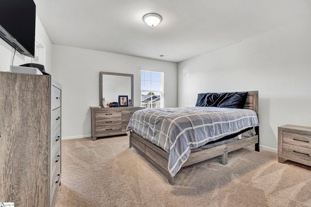 bedroom featuring baseboards and light colored carpet
