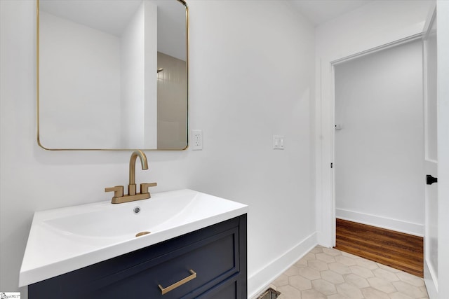 bathroom with tile patterned floors, baseboards, and vanity