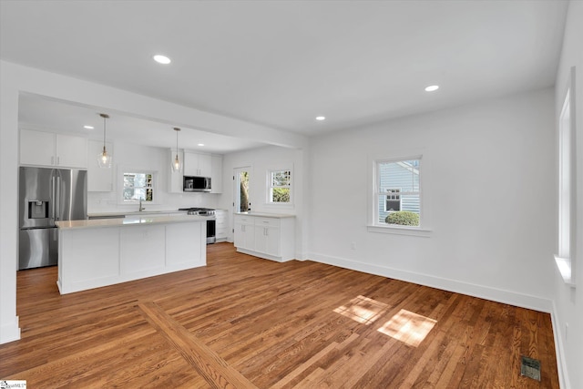 kitchen featuring light countertops, white cabinets, light wood-style floors, visible vents, and stainless steel appliances