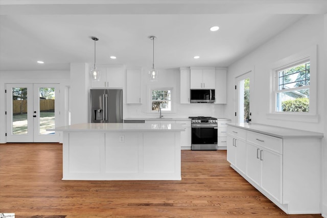 kitchen with light wood-type flooring, a sink, white cabinetry, and stainless steel appliances