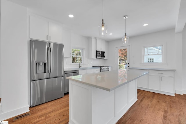 kitchen featuring visible vents, white cabinets, light countertops, light wood-type flooring, and stainless steel appliances
