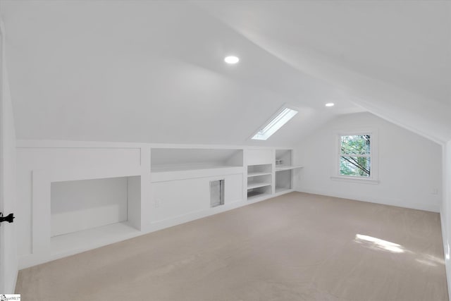 bonus room featuring vaulted ceiling with skylight, built in shelves, visible vents, and carpet floors