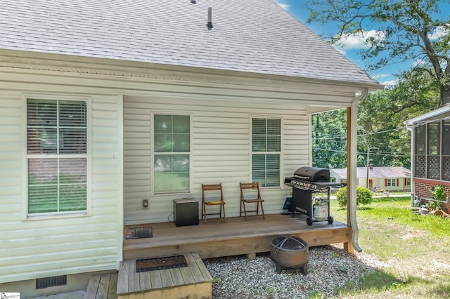 wooden deck with visible vents, a grill, and a sunroom